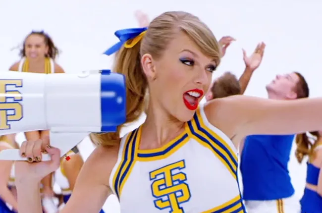 Taylor Swift wearing a cheerleader outfit, which has the letters T and S.